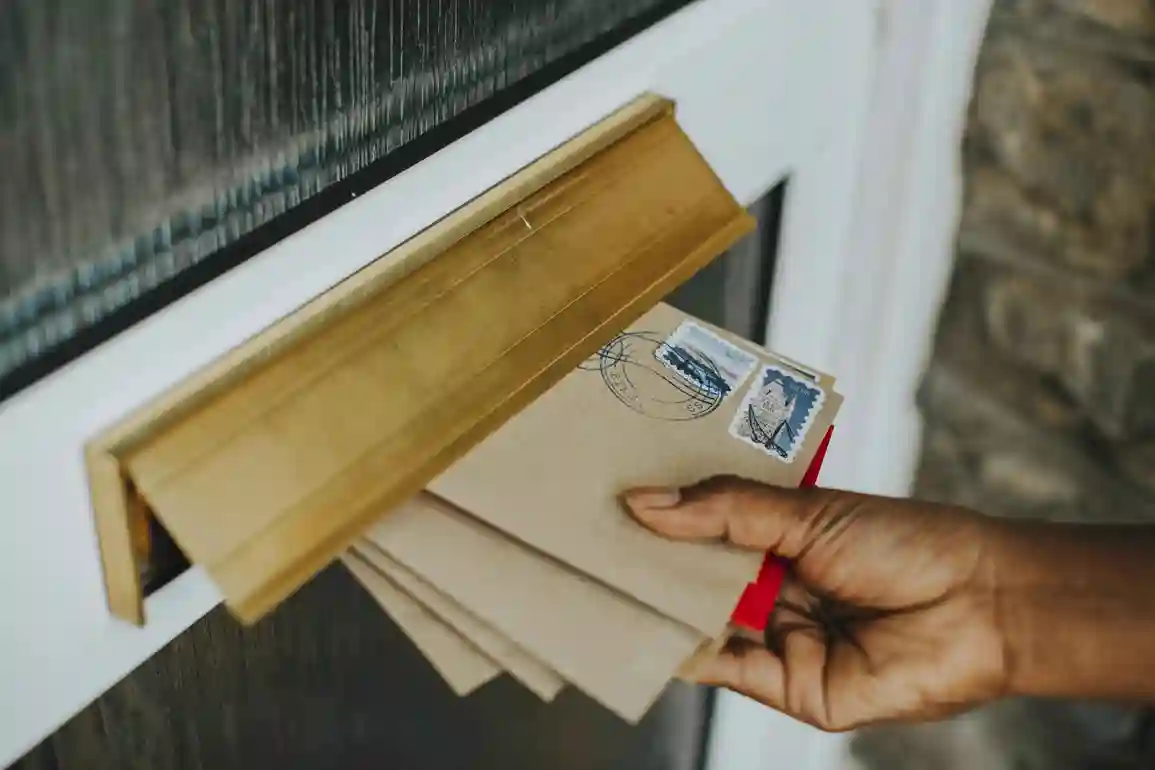 Woman picking-up mail - Book your mailbox now